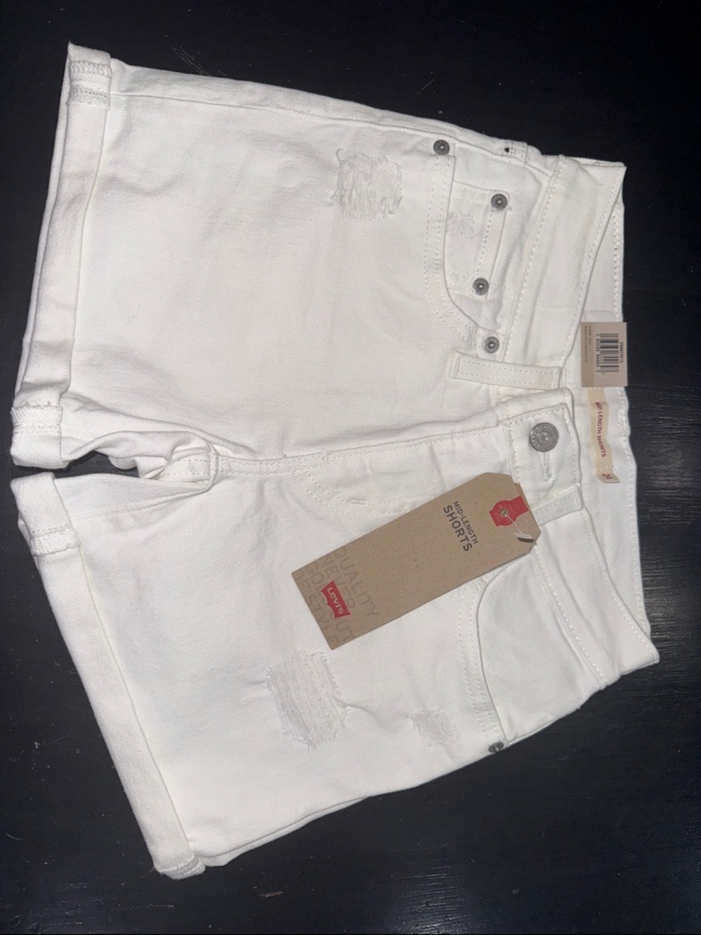 levi’s mid length shorts. white denim. size 24. mid rise. slim thru hip. NEW.